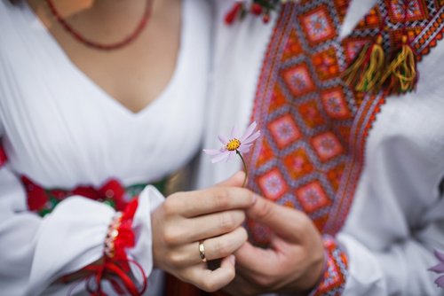 Hände einer weiblichen Person halten eine Blume